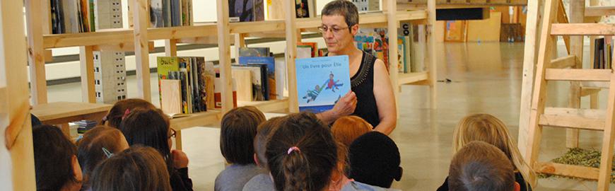 Une animatrice conte une histoire à des élèves de maternelle. PROF/FWB