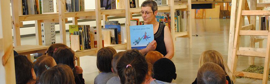 Une animatrice conte une histoire à des élèves de maternelle.  PROF/FWB