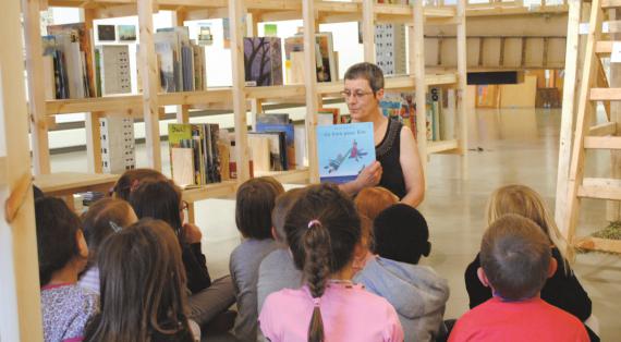 Les enfants écoutent attentivement la conteuse lors de l’exposition Illustre.