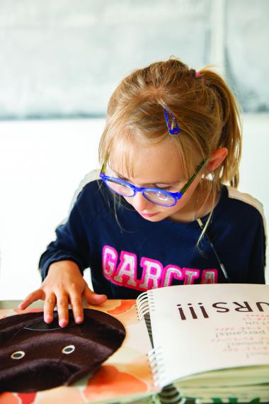 Julia, à la découverte d'un livre tactile.