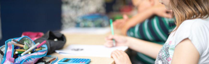 élève de primaire en classe, assise à son banc
